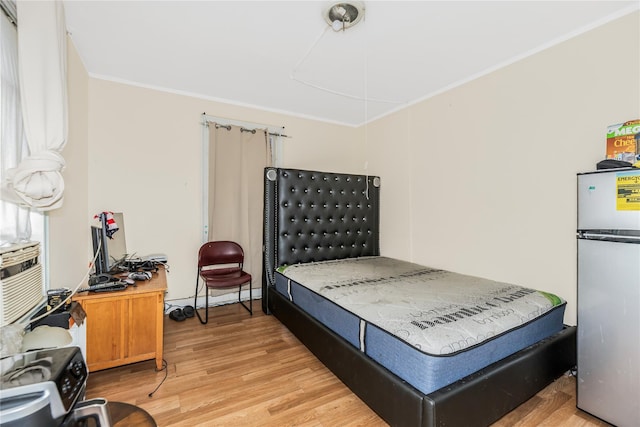 132 Oak St, Yonkers, NY 10701 - bedroom with freestanding refrigerator, light wood-type flooring, and crown molding
