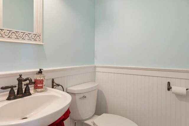 140 Grant Dr, Aquebogue, NY 11931 - bathroom featuring a sink, wainscoting, and toilet