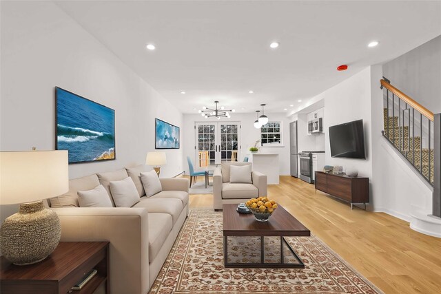 3951 45th St Unit 1, Sunnyside, NY 11104 - living room with light wood finished floors, a chandelier, recessed lighting, stairs, and baseboards