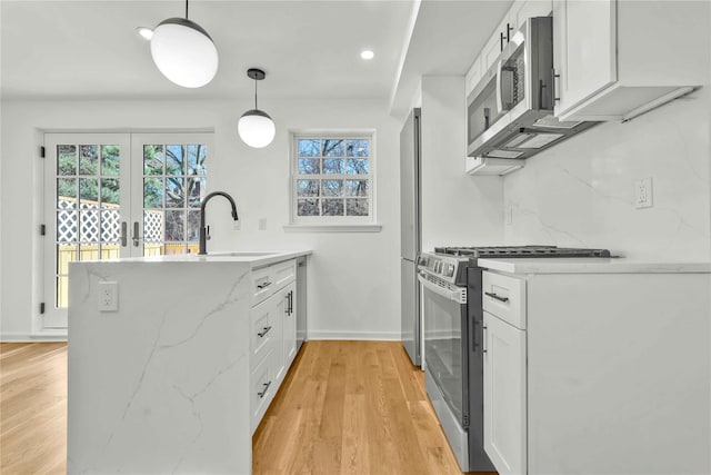 3951 45th St Unit 1, Sunnyside, NY 11104 - kitchen featuring a peninsula, appliances with stainless steel finishes, a sink, white cabinetry, and plenty of natural light