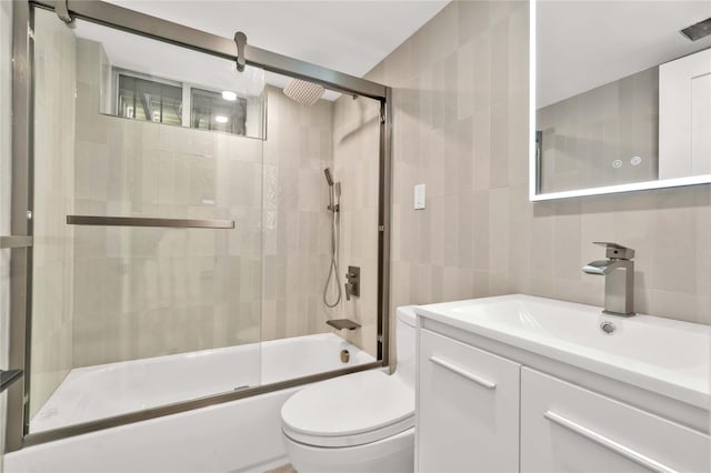 3951 45th St Unit 1, Sunnyside, NY 11104 - bathroom featuring tile walls, bath / shower combo with glass door, vanity, and toilet
