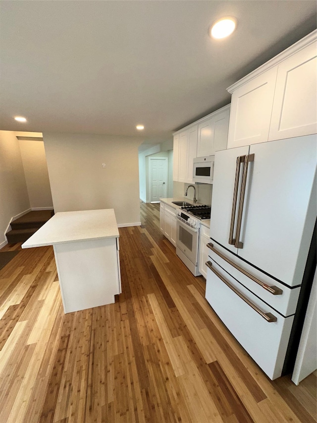 84 Windsor, Hempstead, NY 11550 - kitchen featuring white appliances, a sink, white cabinets, wood finished floors, and recessed lighting