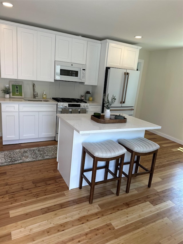84 Windsor, Hempstead, NY 11550 - kitchen featuring white appliances, a sink, recessed lighting, light wood-type flooring, and white cabinetry