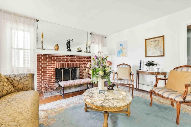 95 Malba Dr Unit 1, Malba, NY 11357 - living area with wood finished floors, a brick fireplace, and a baseboard heating unit