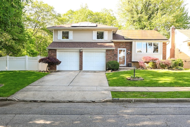 1651 John St, North Merrick, NY 11566 - tri-level home with a garage, brick siding, driveway, and solar panels