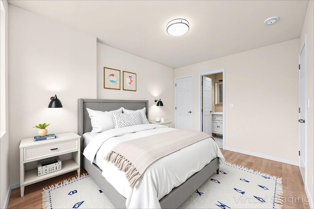 91-23 Corona Ave Unit 2F, Elmhurst, NY 11373 - bedroom with light wood-style floors, baseboards, and connected bathroom