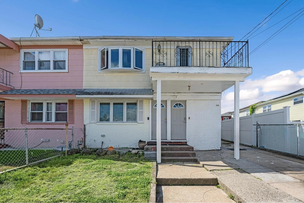 6953 Thursby Ave, Arverne, NY 11692 - view of front of home with a balcony, brick siding, and roof with shingles