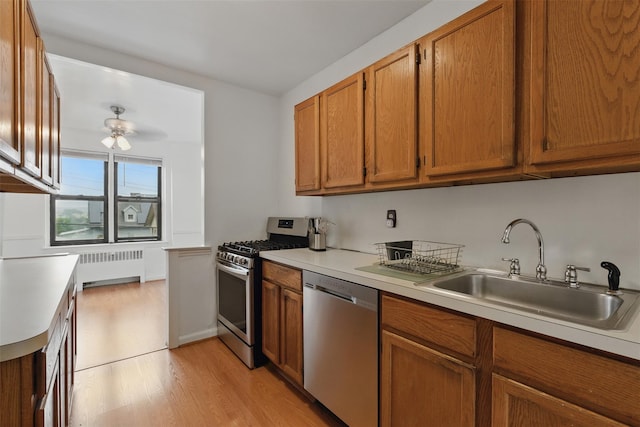 70 Sherman Ave Unit 2G, Yonkers, NY 10705 - kitchen featuring stainless steel appliances, radiator, a sink, light countertops, and light wood-type flooring