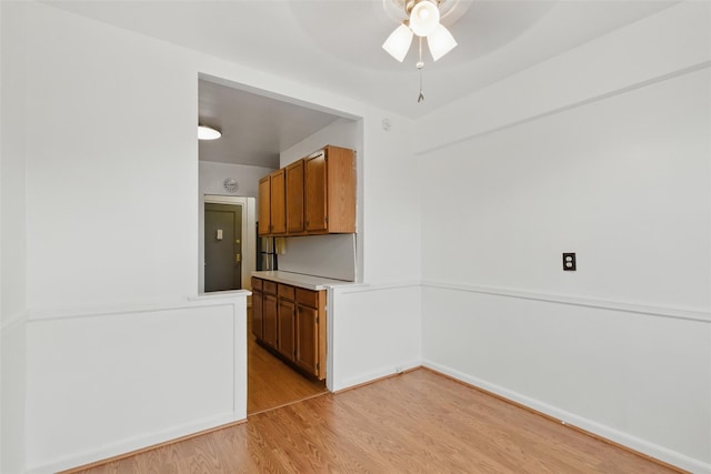 70 Sherman Ave Unit 2G, Yonkers, NY 10705 - kitchen featuring ceiling fan, light wood-style flooring, brown cabinetry, light countertops, and baseboards