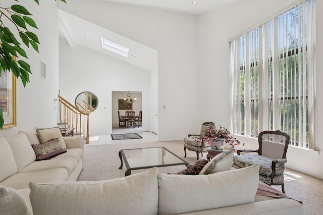 15 Augusta Ln, Manhasset, NY 11030 - carpeted living room featuring healthy amount of natural light, stairs, a skylight, a chandelier, and high vaulted ceiling