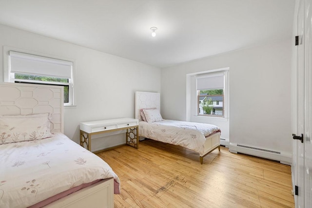 10 Karow Ct, Monsey, NY 10952 - bedroom featuring multiple windows, a baseboard heating unit, and light wood finished floors