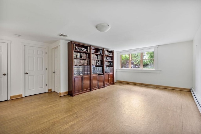 10 Karow Ct, Monsey, NY 10952 - empty room featuring wood finished floors, baseboards, and a baseboard heating unit