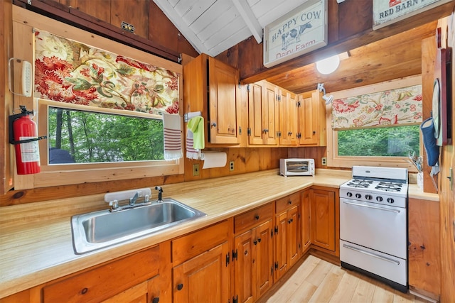 3300 Baker Unit 11, Mohegan Lake, NY 10547 - kitchen featuring white gas range, a sink, light countertops, light wood-style flooring, and brown cabinets