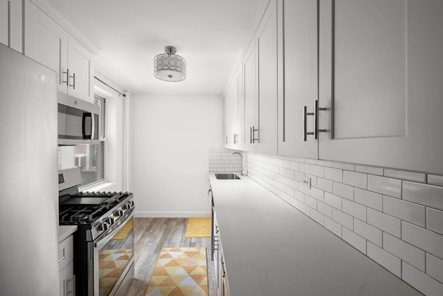 180 Van Cortlandt Park S Unit 4C, Bronx, NY 10463 - kitchen featuring stainless steel appliances, a sink, white cabinetry, tasteful backsplash, and light wood-style floors