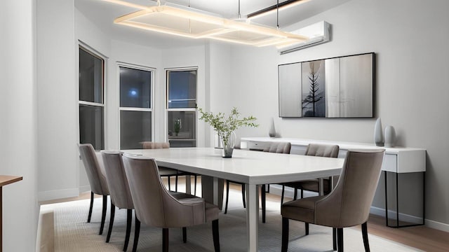 2448 Webb Ave, Bronx, NY 10468 - dining area with a wall unit AC, light wood-style flooring, and baseboards
