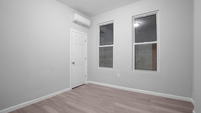 2448 Webb Ave, Bronx, NY 10468 - spare room featuring a wall mounted AC, wood finished floors, and baseboards