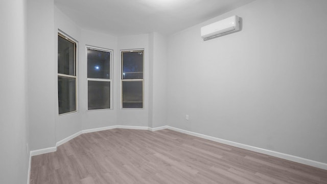 2448 Webb Ave, Bronx, NY 10468 - unfurnished room featuring a wall mounted AC, wood finished floors, and baseboards