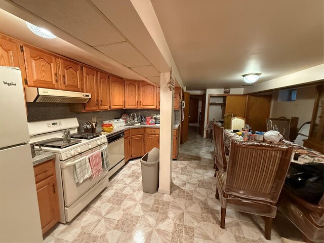 7542 67th Rd, Middle Village, NY 11379 - kitchen featuring white appliances, under cabinet range hood, a sink, and brown cabinetry