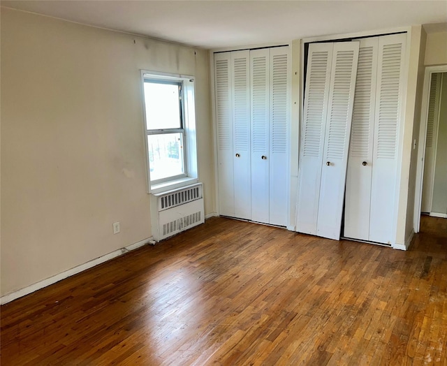 415 Gramatan Ave Unit 5D, Mount Vernon, NY 10552 - unfurnished bedroom featuring multiple closets, radiator heating unit, wood-type flooring, and baseboards