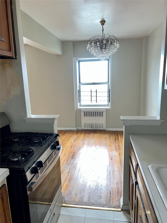 415 Gramatan Ave Unit 5D, Mount Vernon, NY 10552 - kitchen with stainless steel gas range oven, radiator heating unit, a chandelier, light wood finished floors, and baseboards