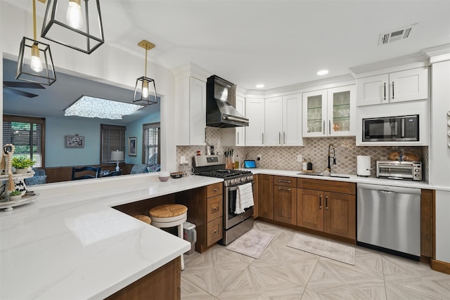 23 Waldron Dr, Stony Point, NY 10980 - kitchen with stainless steel appliances, wall chimney exhaust hood, a sink, pendant lighting, and white cabinets