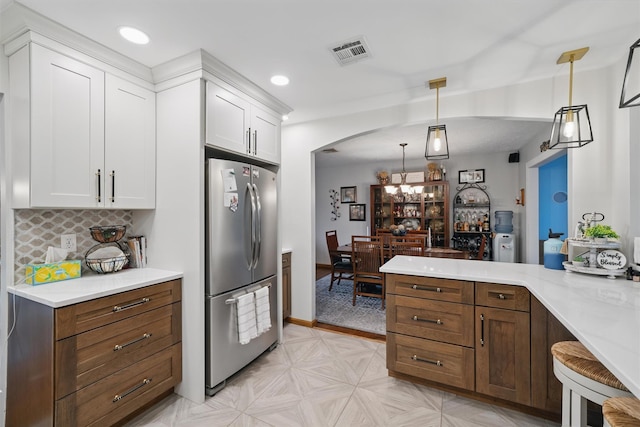 23 Waldron Dr, Stony Point, NY 10980 - kitchen with freestanding refrigerator, arched walkways, white cabinetry, light countertops, and recessed lighting