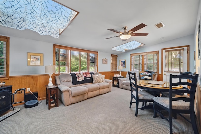 23 Waldron Dr, Stony Point, NY 10980 - carpeted living area featuring a skylight, ceiling fan, wainscoting, wooden walls, and vaulted ceiling