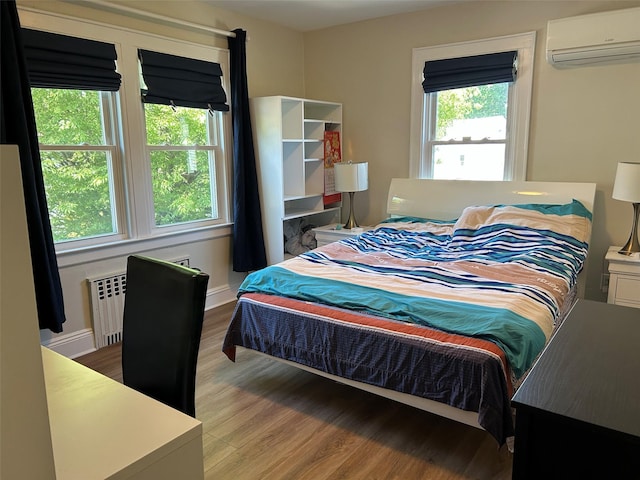13-01 146th Pl, Whitestone, NY 11357 - bedroom featuring a wall mounted air conditioner, radiator, and wood finished floors