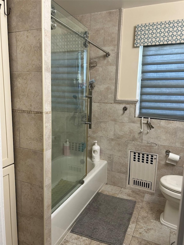 13-01 146th Pl, Whitestone, NY 11357 - full bath featuring radiator heating unit, toilet, bath / shower combo with glass door, tile walls, and tile patterned flooring
