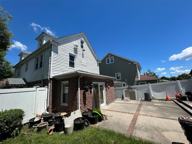 13-01 146th Pl, Whitestone, NY 11357 - rear view of house featuring brick siding, a patio area, and a fenced backyard