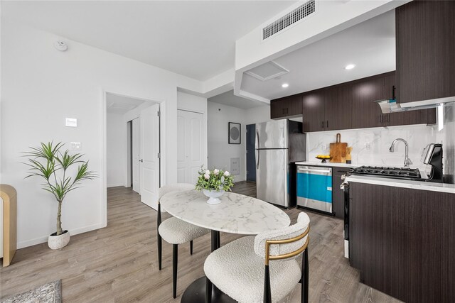 97-30 64th Ave Unit 3B, Rego Park, NY 11374 - kitchen with appliances with stainless steel finishes, dark brown cabinetry, light countertops, light wood-style flooring, and baseboards
