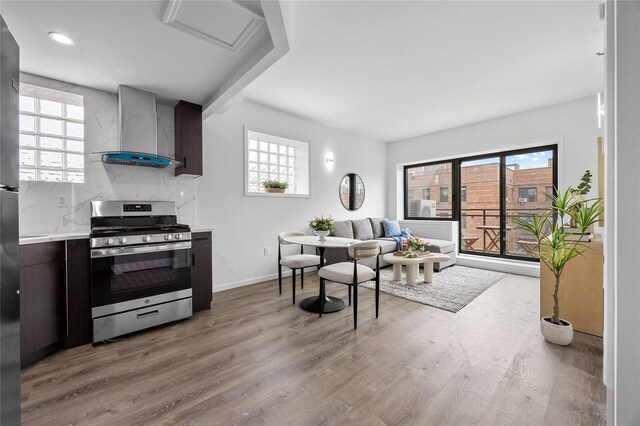 97-30 64th Ave Unit 3C, Rego Park, NY 11374 - kitchen featuring stainless steel gas range oven, wall chimney range hood, light countertops, healthy amount of natural light, and recessed lighting