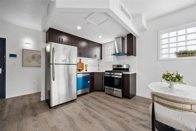 97-30 64th Ave Unit 3C, Rego Park, NY 11374 - kitchen with appliances with stainless steel finishes, wall chimney exhaust hood, dark brown cabinets, light countertops, and recessed lighting
