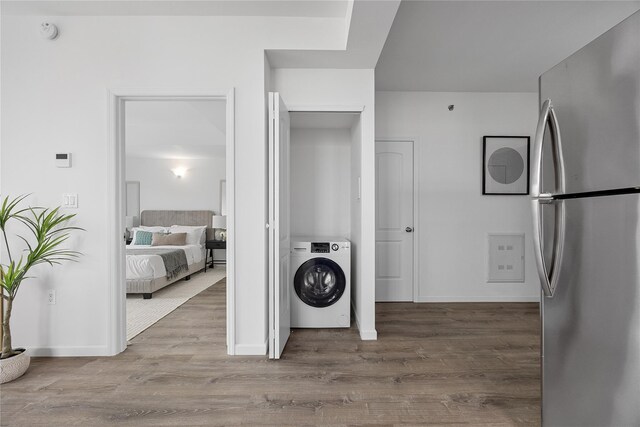97-30 64th Ave Unit 7C, Rego Park, NY 11374 - laundry room with washer / clothes dryer, wood finished floors, and baseboards