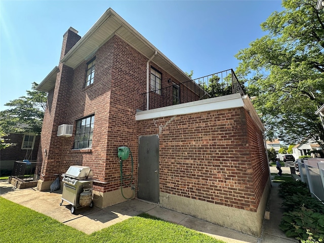 157-18 26th Ave, Flushing, NY 11354 - view of side of property with brick siding, a chimney, a balcony, and a wall unit AC