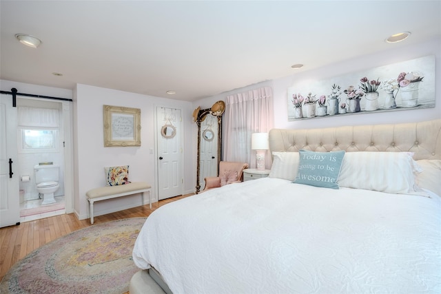 395 Main St, Northport, NY 11768 - bedroom with a barn door, wood finished floors, and ensuite bath