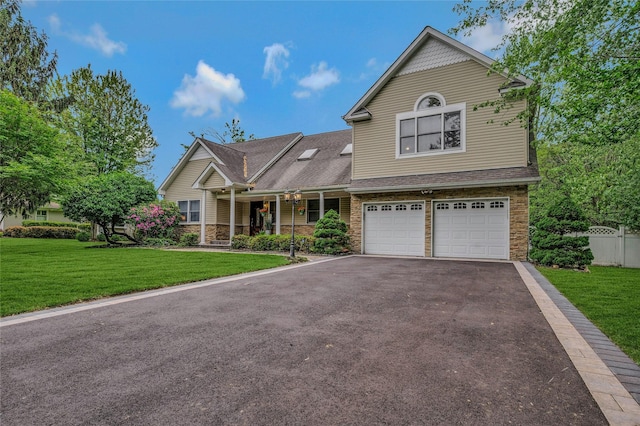 32 Robinhood Ln, East Setauket, NY 11733 - view of front facade with stone siding, asphalt driveway, an attached garage, and covered porch