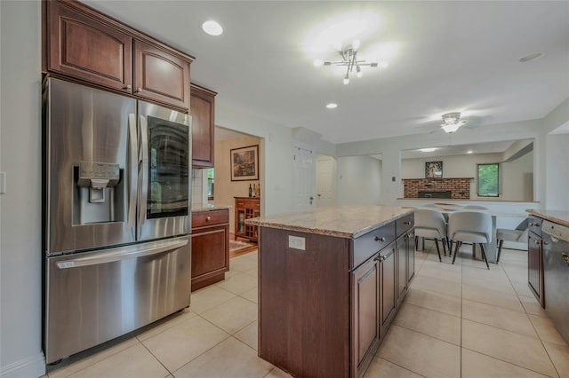 32 Robinhood Ln, East Setauket, NY 11733 - kitchen featuring stainless steel refrigerator with ice dispenser, a kitchen island, light tile patterned flooring, light stone countertops, and ceiling fan