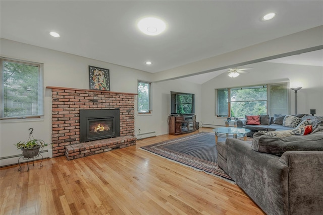 32 Robinhood Ln, East Setauket, NY 11733 - living room featuring a baseboard radiator, healthy amount of natural light, a brick fireplace, wood finished floors, and recessed lighting