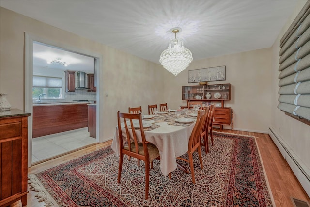32 Robinhood Ln, East Setauket, NY 11733 - dining room with a baseboard radiator, a chandelier, and light wood-type flooring