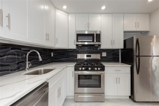 380 N Broadway Unit D4, Yonkers, NY 10701 - kitchen with stainless steel appliances, a sink, white cabinetry, light stone countertops, and backsplash