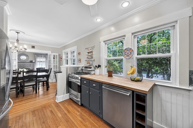 51 S Airmont Rd, Airmont, NY 10901 - kitchen with appliances with stainless steel finishes, wooden counters, light wood-type flooring, a chandelier, and ornamental molding