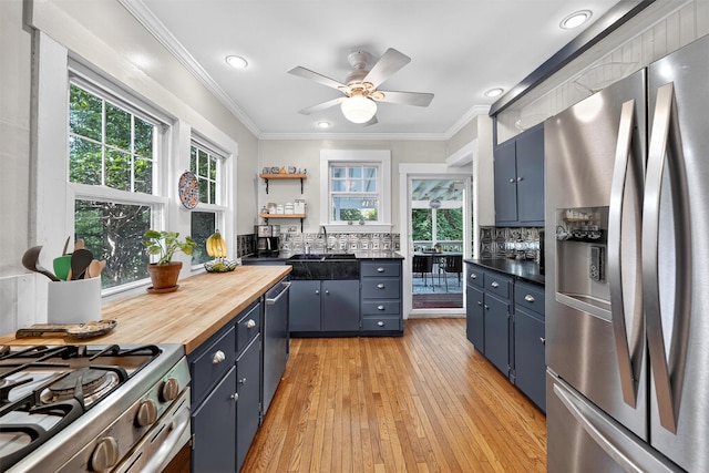 51 S Airmont Rd, Airmont, NY 10901 - kitchen featuring stainless steel appliances, blue cabinets, ornamental molding, light wood finished floors, and wood counters