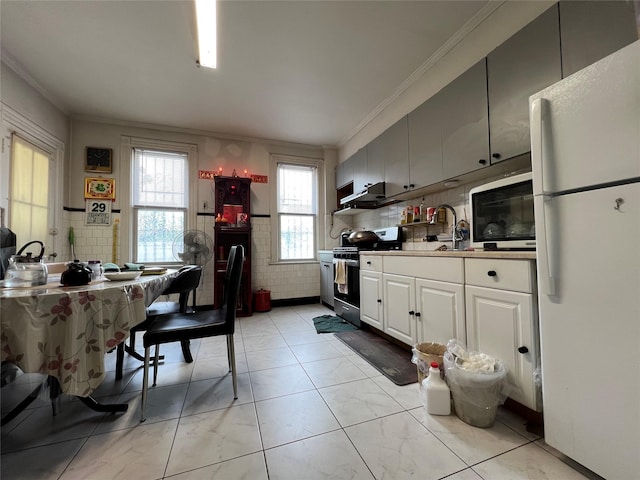 8624 79th St, Woodhaven, NY 11421 - kitchen with stainless steel range, freestanding refrigerator, crown molding, and white cabinets