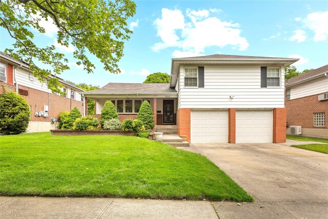 222-47 Garland Dr, Bayside, NY 11364 - tri-level home with a garage, a front lawn, brick siding, and driveway