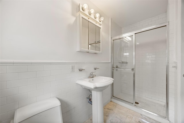 222-47 Garland Dr, Bayside, NY 11364 - bathroom with toilet, a shower stall, wainscoting, tile walls, and a sink
