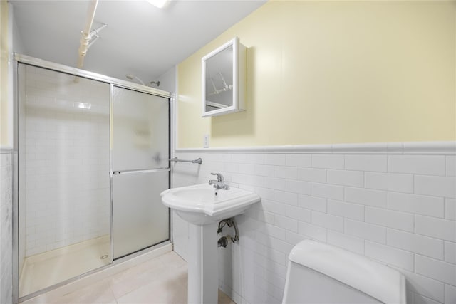 222-47 Garland Dr, Bayside, NY 11364 - full bathroom with toilet, a stall shower, tile patterned floors, a wainscoted wall, and tile walls