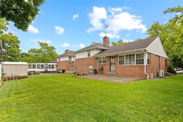 222-47 Garland Dr, Bayside, NY 11364 - back of house featuring brick siding, a patio, a chimney, and a lawn