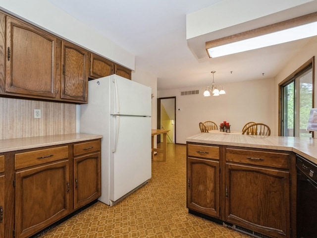 29 Sachson Pl, Wappingers Falls, NY 12590 - kitchen with black dishwasher, freestanding refrigerator, light floors, a chandelier, and light countertops