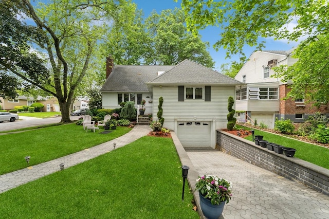 18 Hawthorne Ln, Valley Stream, NY 11581 - view of front facade with a chimney, a garage, decorative driveway, a front yard, and a shingled roof
